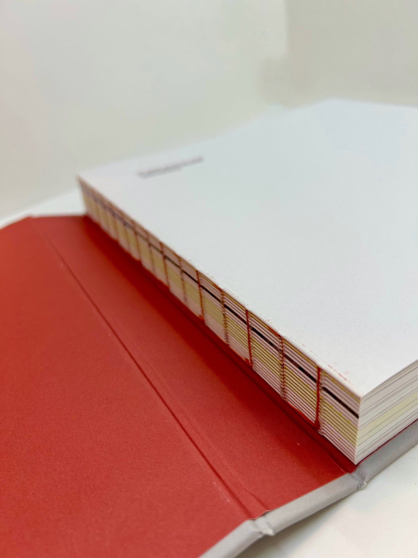 Boken har fortsatt åpen binding i ryggen, men er nå beskyttet av hard rygg ved lagring/frakt