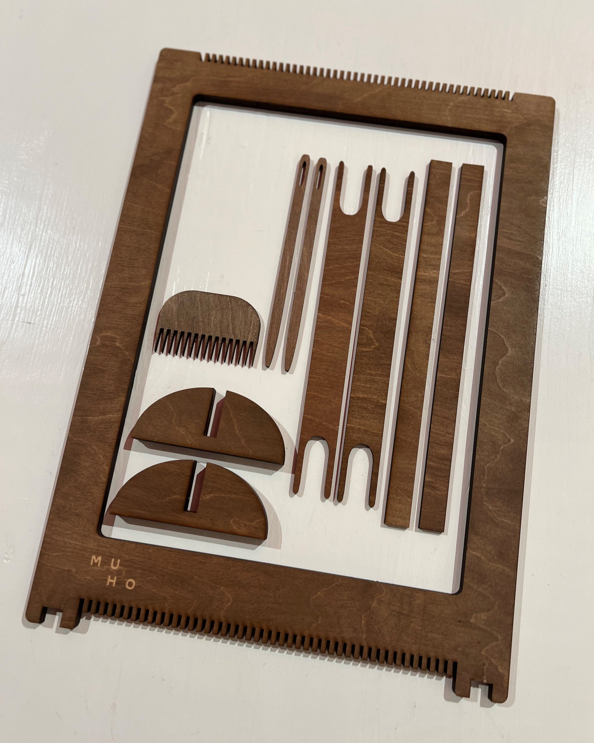 Pakken inneholder vevramme, to skillepinner, to skytler, to nåler, vevkam og bein.