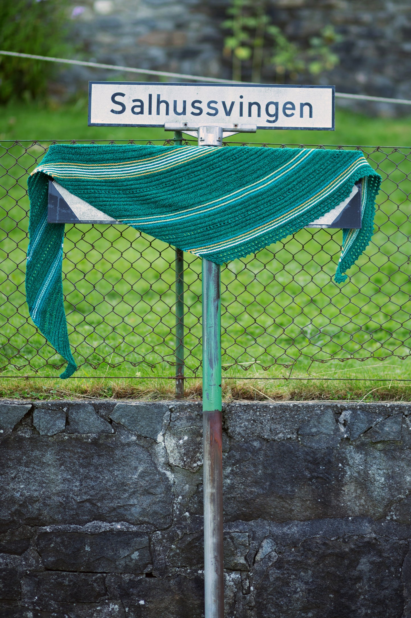 Sjal i Salhussvingen, grønt sjal som henger på skilt