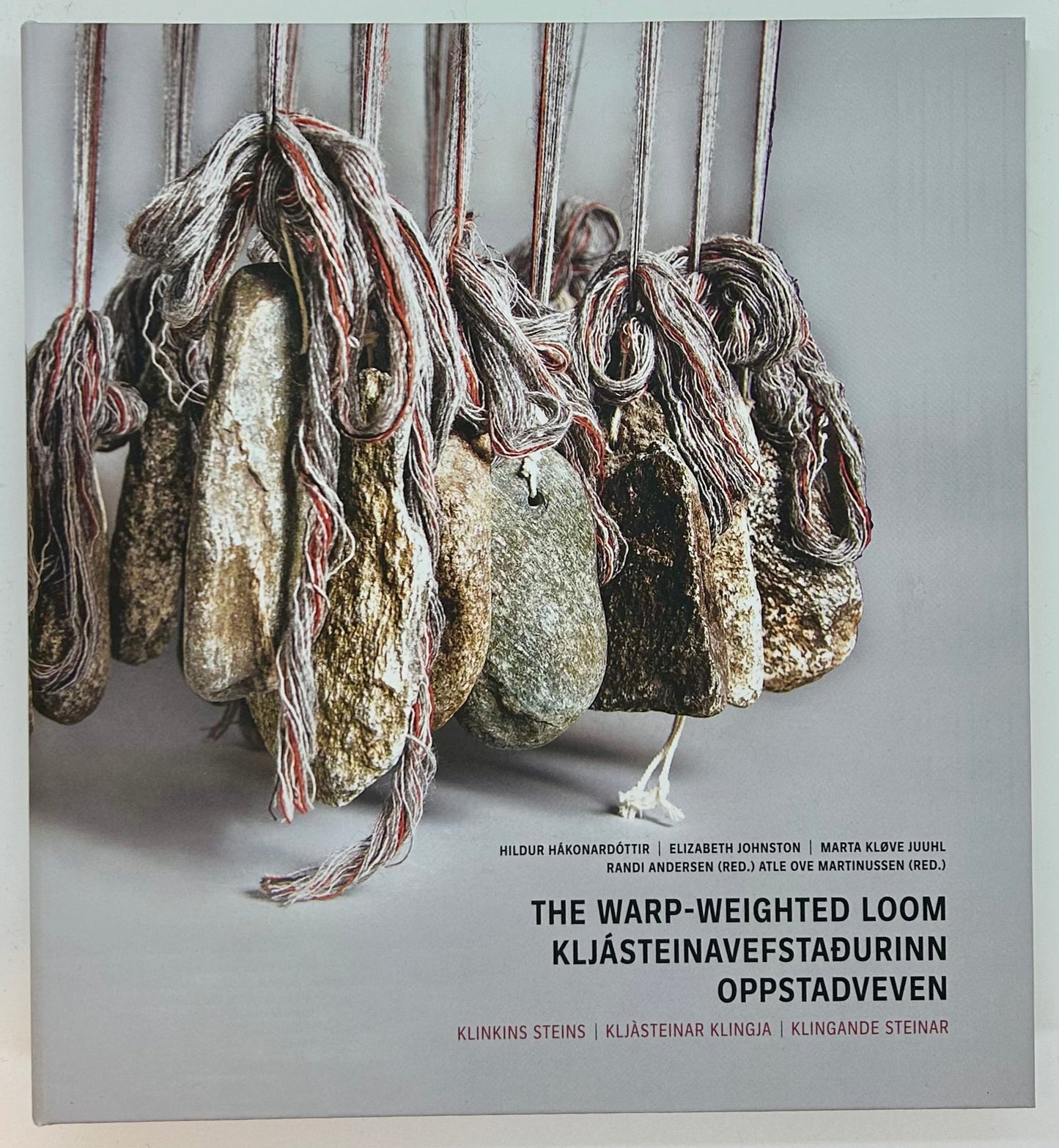 bokfremside med steiner som henger i tau, oppstadvev